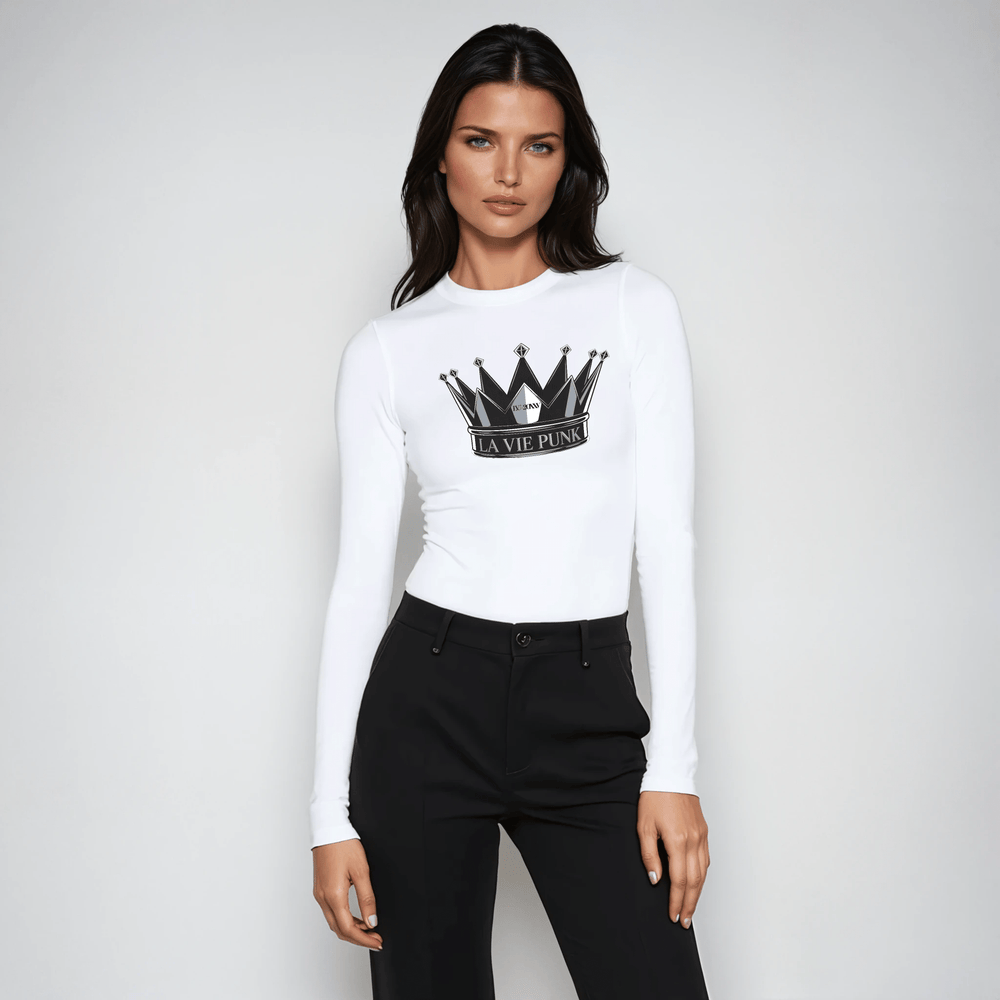Woman wearing white long-sleeve tee with La Vie Punk crown graphic, styled with black high-waisted pants.