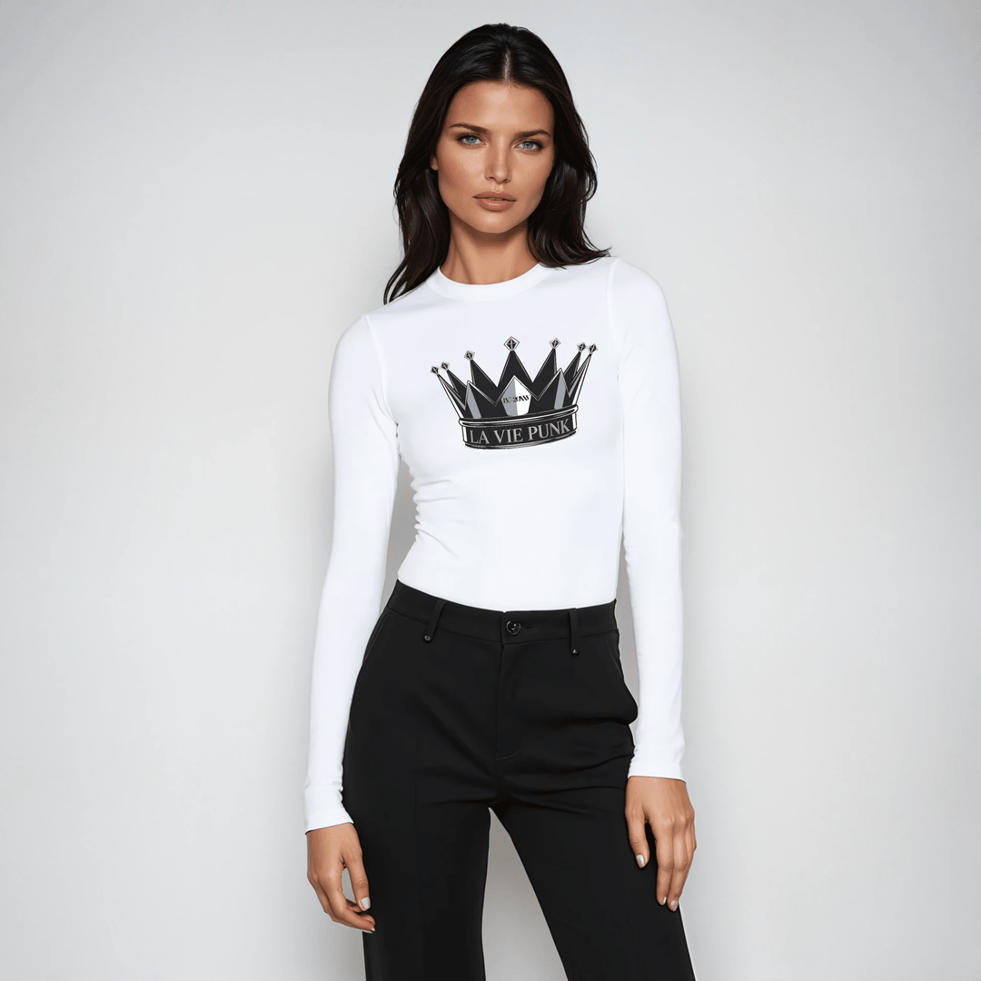 Woman wearing white long-sleeve tee with La Vie Punk crown graphic, styled with black high-waisted pants.